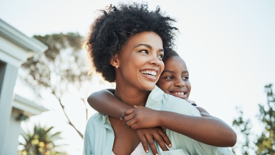 A mother carrying her daughter on her back