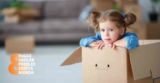 A little girl is deep in thought inside a cardboard box