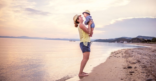 Mother and baby at the beach near the ocean
