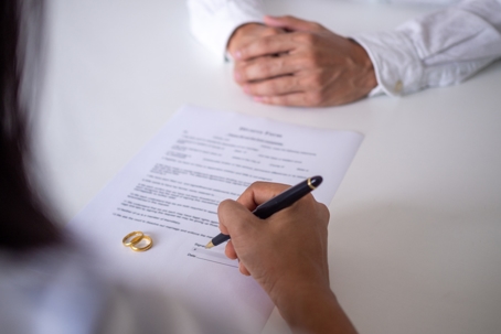 woman signing divorce papers