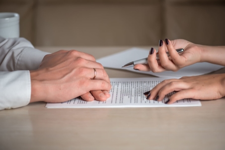 a woman and a man signing a contract